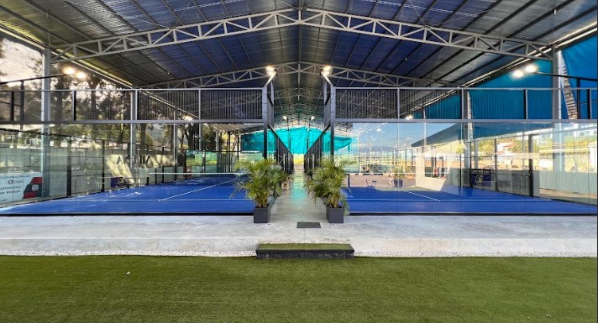 El pasillo central del club entre las canchas techadas, con las palmeras en maceta a la entrada