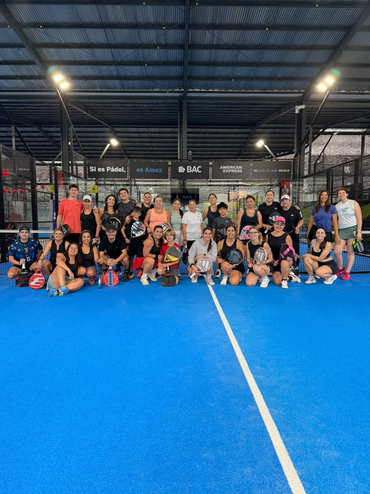Familias enteras, madres, hijos y jugadores, posando en la cancha durante el pozo del Día de la Madre